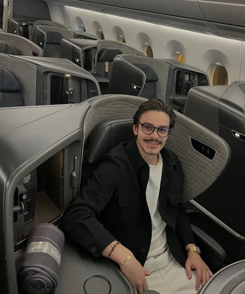 Otávio Barros, CEO da SkyScale, sentado na classe executiva de um avião